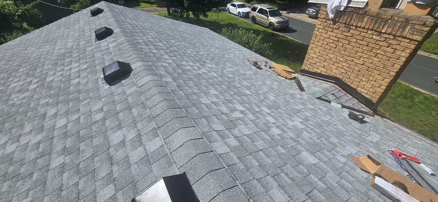 Finished shingles next to brick chimney in the Twin Cities