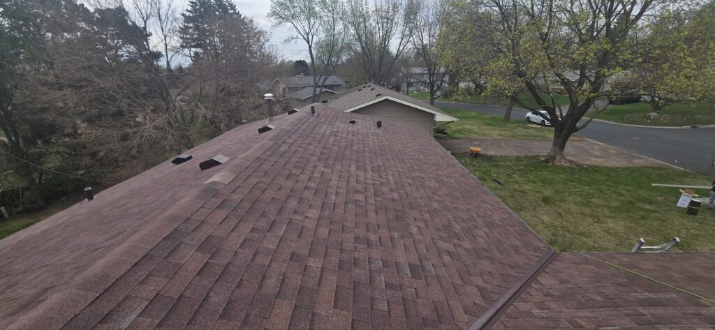 Brown architectural shingle roof with ridge and roof vents.